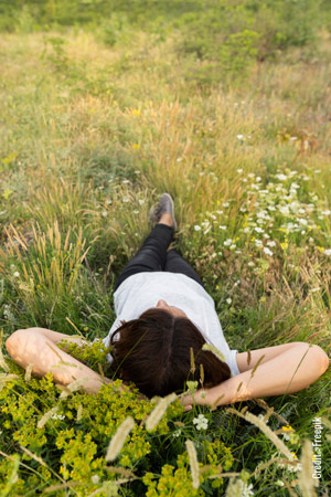 Une personne qui se détend dans l'herbe en regardant le ciel